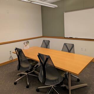 Image of room C48, located in Marx Library.  Room has a table with four chairs and whiteboard on the wall. 