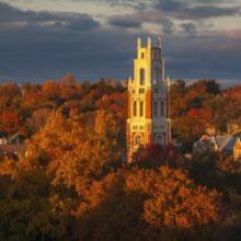 Image of Franklin Tower with dark clouds and brighly colored leaves on the Yale University campus 